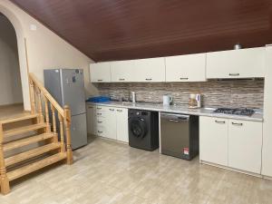 姆茨赫塔Mtskheta Wellpoint Arsukidze 48的厨房配有白色橱柜和一台洗衣机