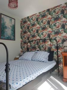 拉贝尔讷里昂雷茨TY BIHAN的一间卧室配有一张带花卉壁纸的床