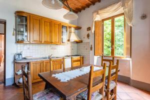 博尔戈阿莫扎诺Casale Poli的厨房配有木桌和桌椅