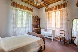博尔戈阿莫扎诺Casale Poli的一间卧室配有一张床、一把椅子和窗户。