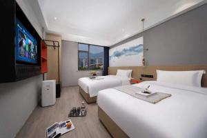 义乌Yiwu Boyi Meiju Hotel义乌市泊忆酒店的酒店客房设有两张床和一台平面电视。