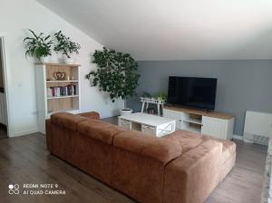 斯利文Уютна къща的客厅配有棕色沙发和平面电视