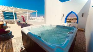 亚喀巴Cloud 7 Residences Ayla Aqaba的带庭院的客房内的热水浴池
