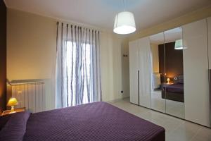 巴里La Dimora Accommodation的一间卧室配有一张紫色的床和一面大镜子