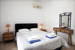 瓦西利基Echinades Resort的一间卧室配有一张床,上面有两条毛巾