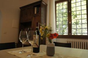 佛罗伦萨Il Sottolo的一张桌子,上面放着两杯酒,花瓶上放着鲜花