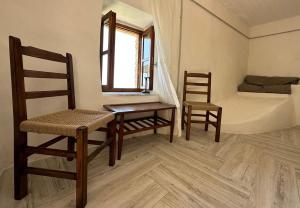 希马拉Amphora Guesthouse & Apartments的一间设有两把椅子、一张桌子和一张床的房间