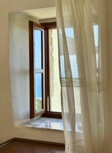 希马拉Amphora Guesthouse & Apartments的窗户,有白色窗帘