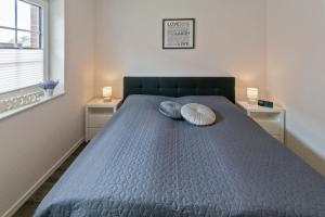 多尔努姆Landhaus Seewind mit Sauna的一间卧室配有一张带两个枕头的床