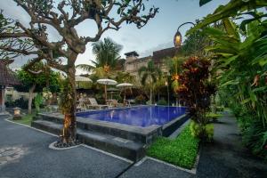 乌布KUDESA Homestay by Pramana Villas的一座种植了树木和植物的庭院内的游泳池