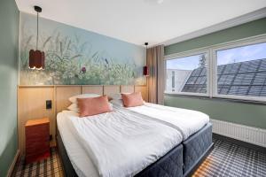 科林基拉科利布雷克索科斯酒店的卧室配有一张带粉红色枕头的大床