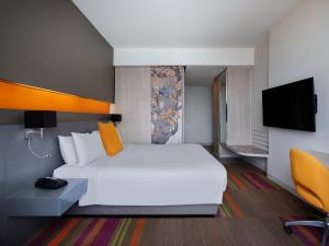 曼谷曼谷暹罗美居酒店的一间酒店客房,配有白色的床和电视