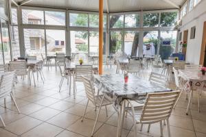 杜布罗夫尼克HI Hostel Dubrovnik的餐厅设有白色的桌椅和窗户。
