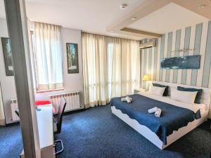 第比利斯萨尼酒店的一间卧室配有一张大床和两条毛巾
