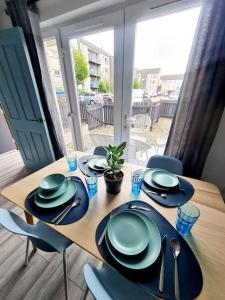 格拉斯哥Spacious 5bed house, FREE parking, NO PARTY !的一张木桌,上面有盘子和餐具