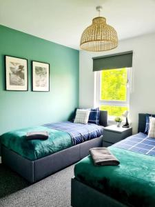 格拉斯哥Spacious 5bed house, FREE parking, NO PARTY !的一间卧室配有两张床和吊灯。