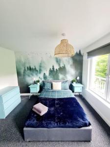 格拉斯哥Spacious 5bed house, FREE parking, NO PARTY !的卧室配有一张床,墙上挂有绘画作品