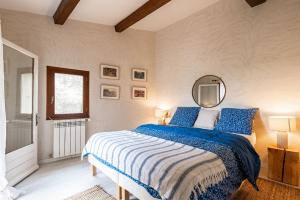贝端Au petit bonheur的卧室配有蓝色和白色的床和镜子
