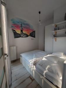 弗罗茨瓦夫Apartment Ksiecia Witolda 43的卧室配有一张床,墙上挂有绘画作品