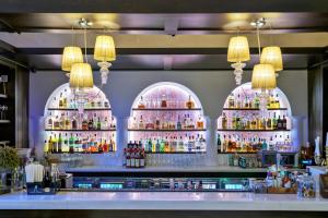 布加勒斯特埃珀科酒店 - 罗莱夏朵精品酒店集团的一间酒吧,里面装有几个酒瓶