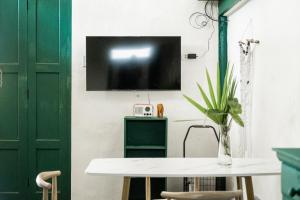 Ban NokLeela Garden Resort的一间设有桌子的房间和墙上的电视