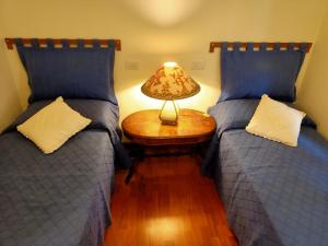 马西亚娜马里纳Appartamento Teresina的一间卧室配有两张床和一张带台灯的桌子
