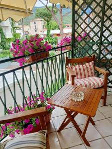 马西亚娜马里纳Appartamento Teresina的阳台配有桌子、长凳和鲜花