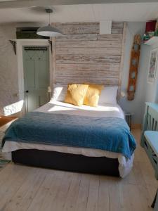 CalstockThe Artist's Retreat的一间卧室设有一张带木墙的大床