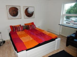 库拉萨Kummelefort的一间卧室配有一张带彩色毯子的床