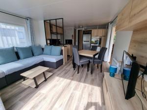 利托Mobil-home 2023 RapidHome Panorama 3 chambres 6 vélos lave-vaisselle 2 piscines couvertes的客厅配有沙发和桌子