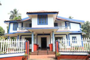 卡乌罗西姆Dona Sa Maria Eco Hotel的白色的蓝色房屋,设有白色的围栏