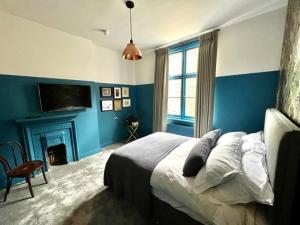 伦敦The Crown Rooms的蓝色卧室设有一张床和一个壁炉