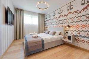 什切尔克Apartamenty Pod Gondolą - Mountain Resort Villa z sauną - Dream Apart的一间卧室配有一张床,墙上配有电视