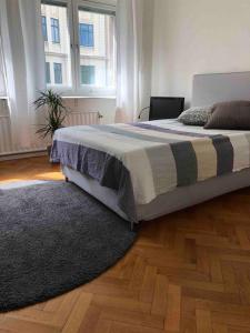赫尔辛堡Stor lägenhet - 150 meter från havet.的一间卧室配有一张带地毯的床和两个窗户