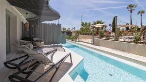 皮内达德马尔Golden Taurus Aquapark Resort的一个带椅子的庭院和一个游泳池