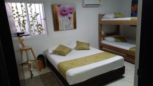 卡塔赫纳Casa Hotel Manga Mar的一间卧室设有两张床和窗户。