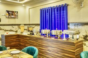 班加罗尔SM Royal Stay Hotel - Near Bangalore international Airport的一间配备有蓝色椅子和桌子的用餐室