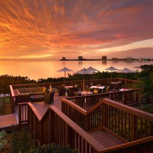 坦帕坦帕湾凯锐豪华酒店的日落时分带桌子和遮阳伞的庭院