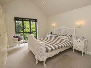 福丁布里奇Appletree Cottage的白色的卧室设有白色的床和窗户。