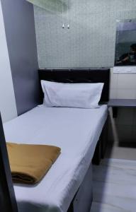 孟买Ared Space-Near Vile Parle Railway Station的一张带白色床单和枕头的床