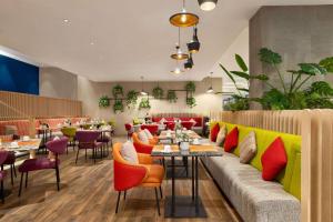 迪拜La Quinta by Wyndham Dubai Jumeirah的餐厅配有色彩缤纷的家具和桌椅