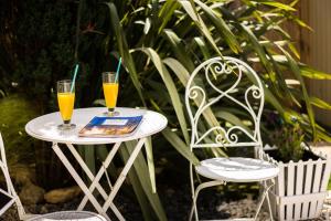 斯达林Delight Corfu Apart Hotel, Sidari的桌子上放着两杯橙汁,还有两把椅子