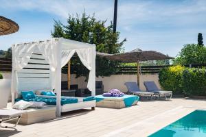 斯达林Delight Corfu Apart Hotel, Sidari的游泳池旁带床和椅子的庭院