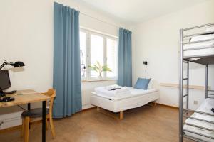 哈诺桑德Härnösands folkhögskolas Bed & Breakfast的一间卧室配有一张床和一张书桌