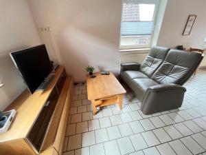 KreuzauAppartementhaus Schlagstein App3的带沙发、电视和桌子的客厅