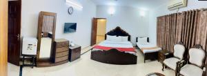 伊斯兰堡Capri Residency的一间卧室配有一张床、梳妆台和电视。