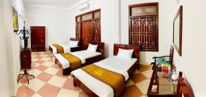 Ban Hin LomNhà nghỉ Xuân Long - Xuan Long gues - Tỉnh Điện Biên的一张位于带 ⁇ 形地板的客房内的两张床