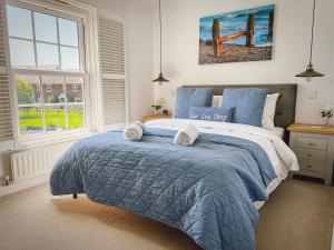 坎伯利Beach Boutique的一间卧室配有蓝色的床和毛巾