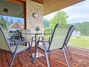 托波尔希卡Apartment HORTENZIJA near Terme Topolšica的露台配有椅子和桌子,甲板上配有桌子