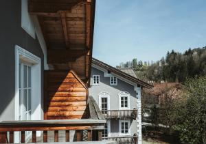 基茨比厄尔HENRI Country House Kitzbühel的白色的房子设有木门廊和阳台